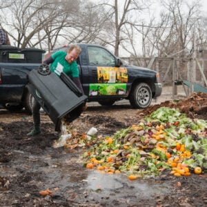 John Taube, a member of the Green Team dumps scraps to compost compost at the farm on Saturday, March 2, 2019.  (Photo by Stephen Bybee)